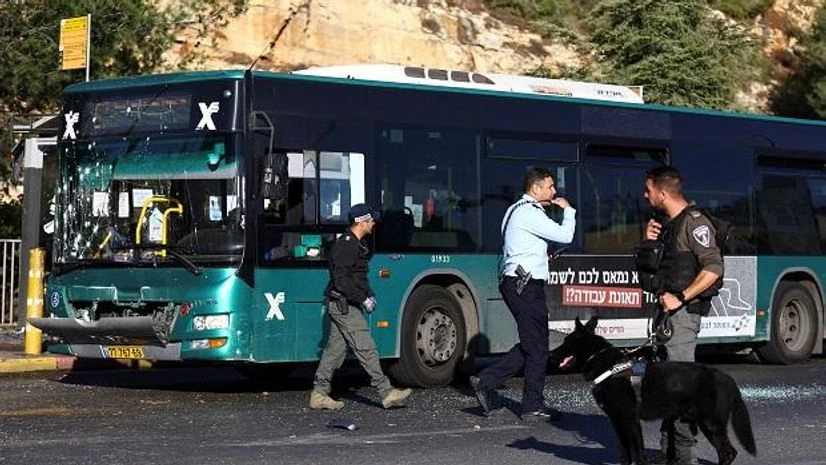 Jerusalem A police officer holds a dog next to a damaged bus following an explosion at a bus stop in Jerusalem November 23, 2022. REUTERS/Ronen Zvulun