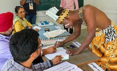 Gujarat polls: Villagers claim they boycotted voting over flogging incident **EDS: TWITTER IMAGE VIA @ECISVEEP** Gir Somnath: A voter from Siddi Community in a traditional attire goes through the election procedure to cast his vote for the 1st phase of the Gujarat Assembly elections, at Madhupur Jambur, in Gir Somnath, Thurs