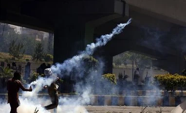 Audio leaks suggest PTI leadership behind attack on official's residence A supporter of Pakistan's former Prime Minister Imran Khan hurls back a tear gas shell toward police as he and others were protesting against the arrest of their leader, in Peshawar, Pakistan, Wednesday, May 10, 2023. (Photo: AP/PTI)