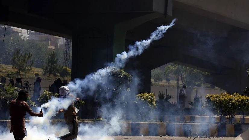A supporter of Pakistan's former Prime Minister Imran Khan hurls back a tear gas shell toward police as he and others were protesting against the arrest of their leader, in Peshawar, Pakistan, Wednesday, May 10, 2023. (Photo: AP/PTI) A supporter of Pakistan's former Prime Minister Imran Khan hurls back a tear gas shell toward police as he and others were protesting against the arrest of their leader, in Peshawar, Pakistan, Wednesday, May 10, 2023. (Photo: AP/PTI)