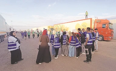 Prepare to deploy, US troops told; Biden to visit Israel on Wednesday Volunteers wait next to a convoy of trucks carrying aid from Egyptian NGOs for Palestinians at the Rafah crossing photo: reuters