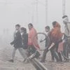 Commuters cross a railway track amid fog on a cold winter morning, in Gurugram, Thursday, Nov. 30, 2023. (PTI Photo)