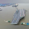 China's third aircraft carrier Fujian Photo taken on May 1, 2024, showing tugboats towing China's third aircraft carrier, the Fujian, away from a dock in east China's Shanghai. The Fujian recently set out for its maiden sea trials. (Photo by Pu Haiyang/Xinhua)