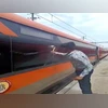 A man smashing the window with a hammer of a stationary Vande Bharat Express A man smashing the window with a hammer of a stationary Vande Bharat Express