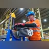 A worker prepares to wrap cold drawn stainless steel bars at a factory in Sheffield