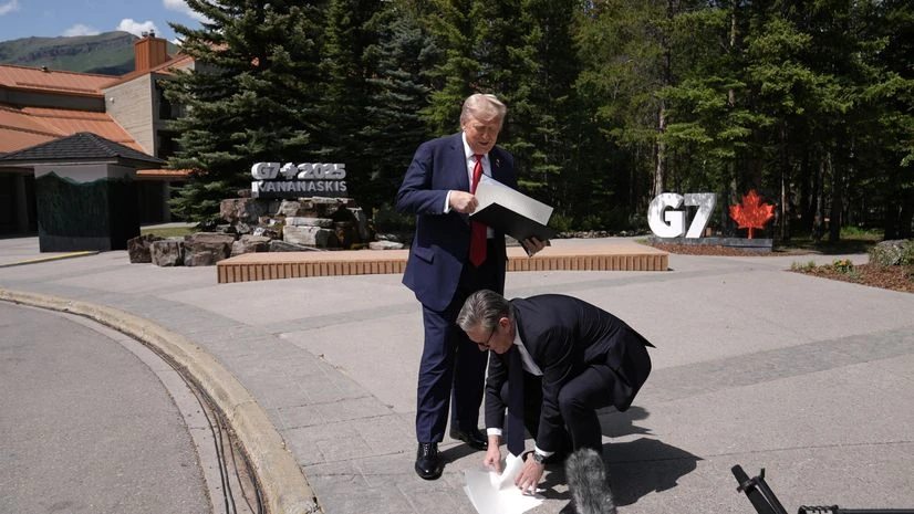 Donald Trump, Keir Starmer UK Prime Minister Keir Starmer picks up papers dropped by Donald Trump.