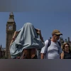 A woman covers her head from the sun on Westminster Bridge in London,  on June 19