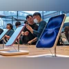 A shop assistant serves a customer inside the Apple Inc. Sanlitun store in Beijing, China