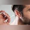 man cleaning ear with cotton buds