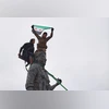 Syrian government soldiers wave a Syrian flag after climbing atop a statue of a female Kurdish fighter, following the takeover of the town from U.S.-backed Syrian Democratic Forces (SDF) | AP Syrian government soldiers wave a Syrian flag after climbing atop a statue of a female Kurdish fighter, following the takeover of the town from U.S.-backed Syrian Democratic Forces (SDF) | AP