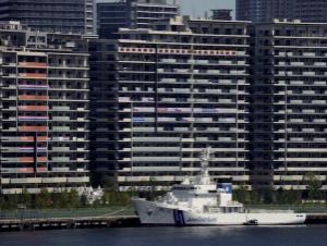 National banners hang from balconies at an athlete's village as Tokyo prepares for the 2020 Summer Olympics, Sunday, July 18, 2021. The pandemic-delayed games open on July 23 without spectators at most venues. (AP Photo/Charlie Riedel)