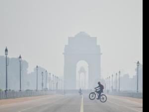 A cyclist rides a bicycle near India Gate covered with a thick layer of smog as the air quality deteriorates due to air pollution, in New Delhi on Thursday.