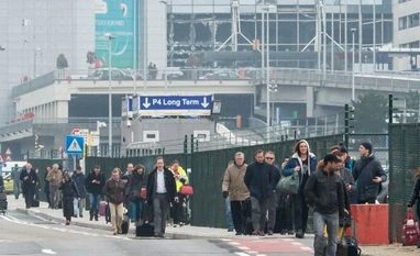 Belgium's neighbours tighten borders security after Brussels explosions People walk away from Brussels airport after explosions rocked the facility in Brussels, Belgium