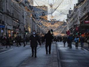 A man wears a face mask while he walks in Regent Street, ahead of the new Tier-4 restriction measures, in London, Saturday, Dec. 19, 2020