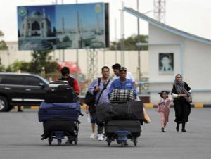 Passengers walk to the departures terminal of Hamid Karzai International Airport in Kabul, Afghanistan, Saturday, Aug. 14, 2021.