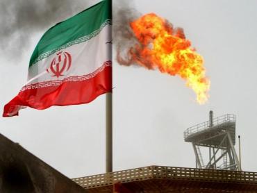 A gas flare on an oil production platform in the Soroush oil fields is seen alongside an Iranian flag in the Persian Gulf, Iran Photo: Reuters