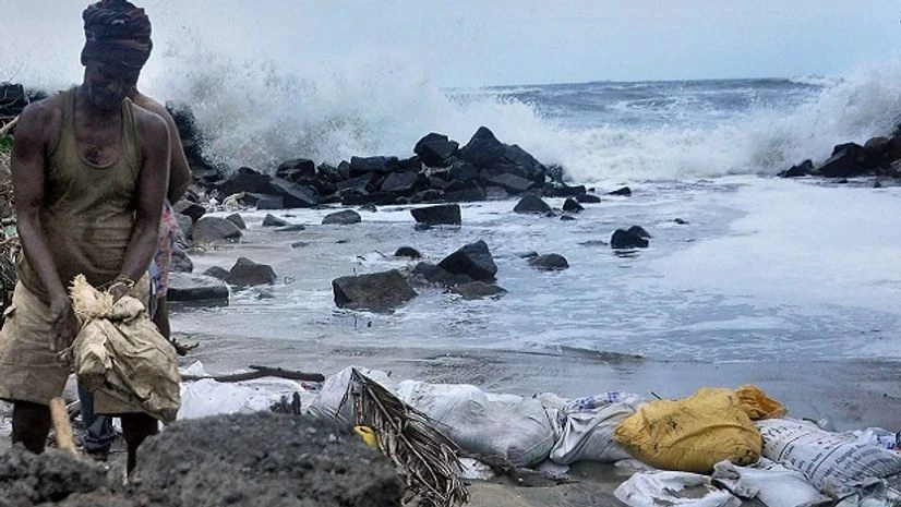A relief worker places sand bags on the banks of a beach in Kochi in wake of cyclone Ockhi on Saturday. (Photo: PTI) A relief worker places sand bags on the banks of a beach in Kochi in wake of cyclone Ockhi on Saturday. (Photo: PTI)
