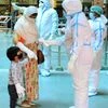 Health workers wear PPE kit conduct thermal screening on passengers as they arrive at Howrah Station, in Kolkata on Thursday.