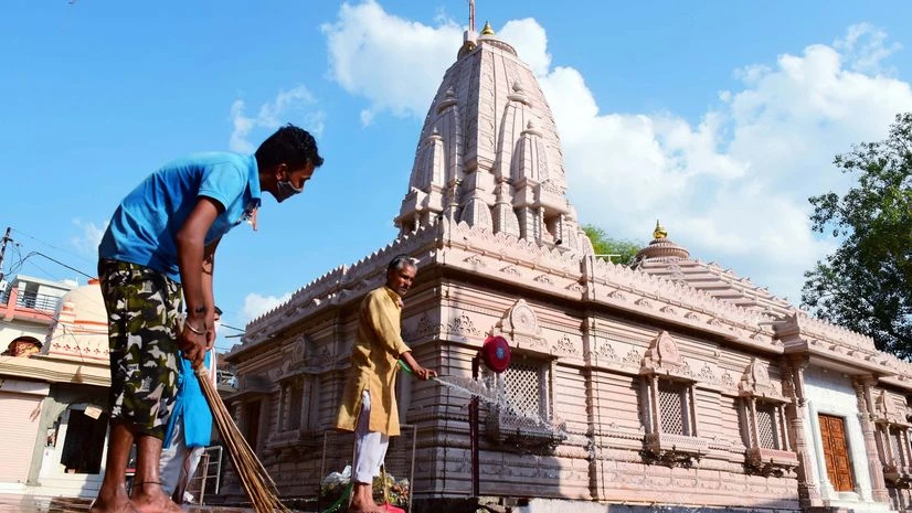temples, lockdown Workers cleaning disinfectant at Maa Badi Khermai temple ahead of its re-opening, during the ongoing COVID-19 lockdown, in Jabalpur on Saturday.