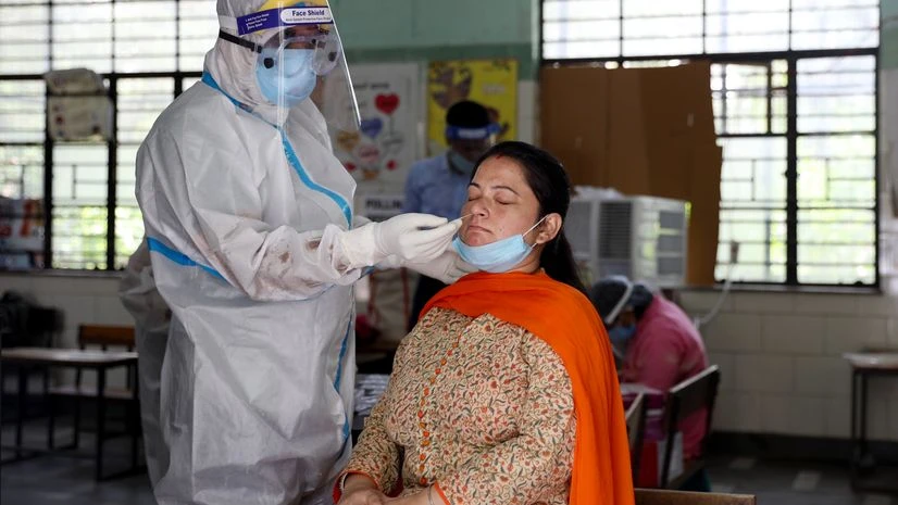 Coronavirus test, Covid-19 test A health official collects a swab sample from a woman to test for the Covid-19 inside a government school, in New Delhi. Photo: ANI