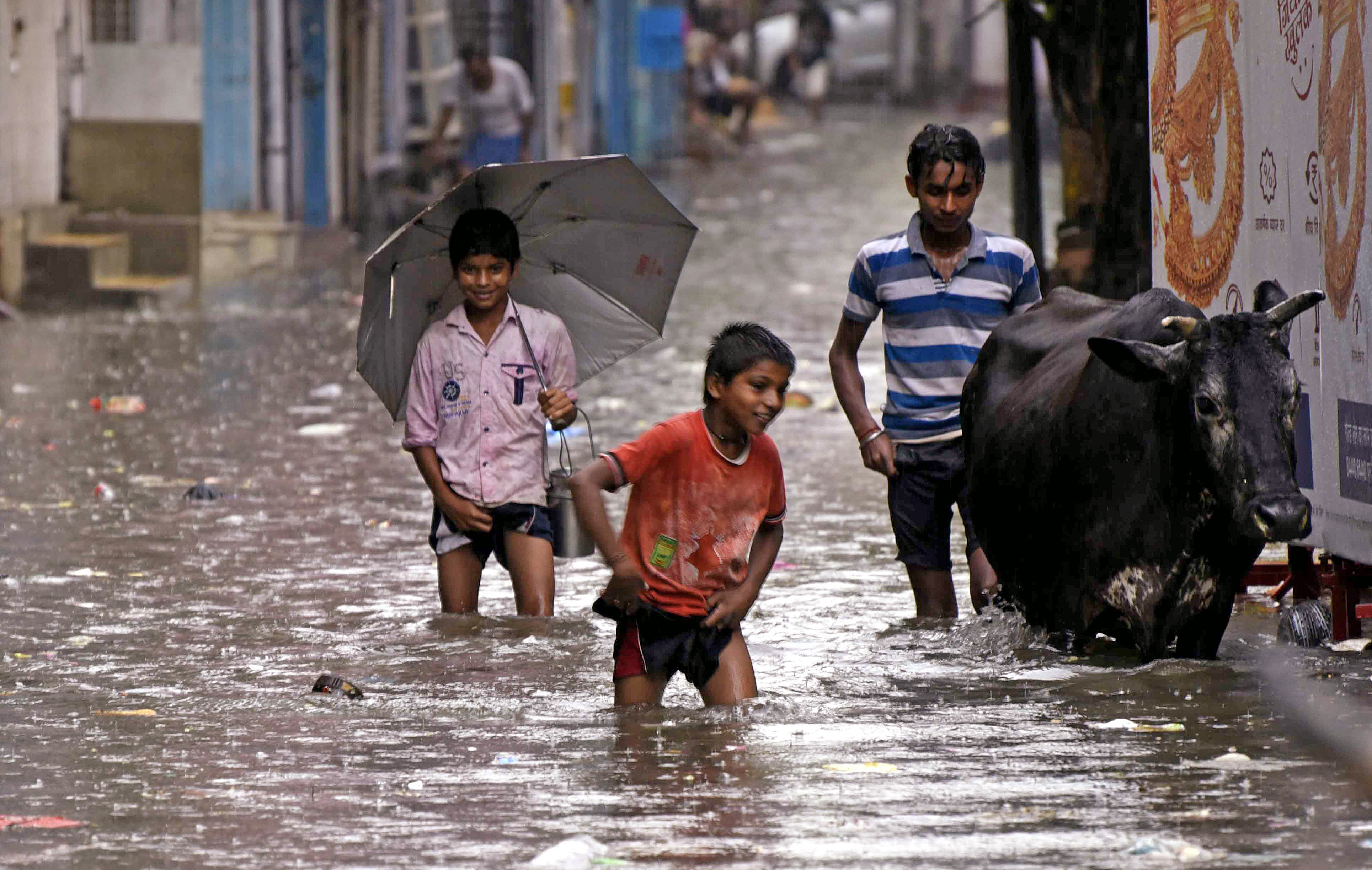 Children wade through waterlogged street after heavy rainfall, in Patna Children wade through waterlogged street after heavy rainfall, in Patna
