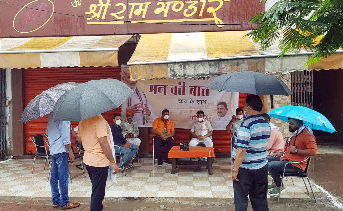 People hold umbrella listening 'Mann Ki Baat' programme through radio during rain in Varanasi People hold umbrella listening 'Mann Ki Baat' programme through radio during rain in Varanasi