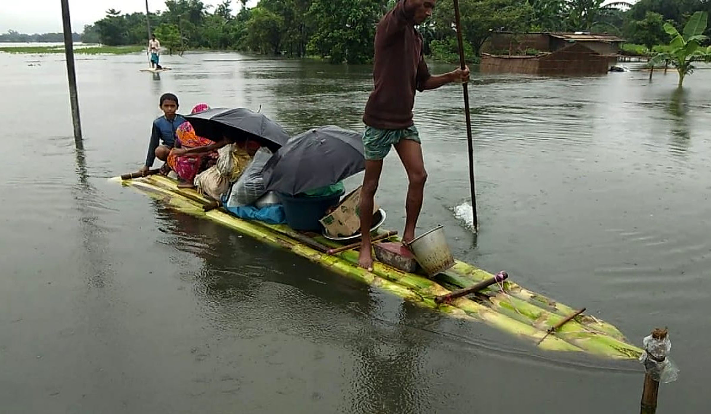 Villagers carrying their belongings move to a safer place through a makeshift boat, after their houses submerged in water due to heavy rainfall, in Bongaigaon on Saturday Villagers carrying their belongings move to a safer place through a makeshift boat, after their houses submerged in water due to heavy rainfall, in Bongaigaon on Saturday
