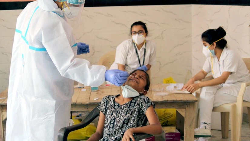 Coronavirus, RAT, rapid antigen testing A health worker collects a swab sample for Covid-19 Rapid antigen testing in Shivji Park containment zone area at Radha Krishna Mandir, in Gurugram.