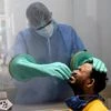 Health worker collects nasal sample from a man for Covid-19 test, in New Delhi.