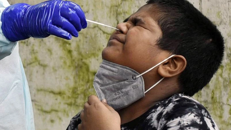 Coronavirus test, coronavirus, Covid-19 A health worker collects a nasal sample from a child for COVID-19 test during the total lockdown imposed by the state government due to surge in Covid-19 cases, in Patna on Monday. Photo: ANI