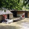 Children take shelter on a boat after their house is partially submerged under floodwaters in a flooded area at Sonitpur, in Guwahati on Sunday.