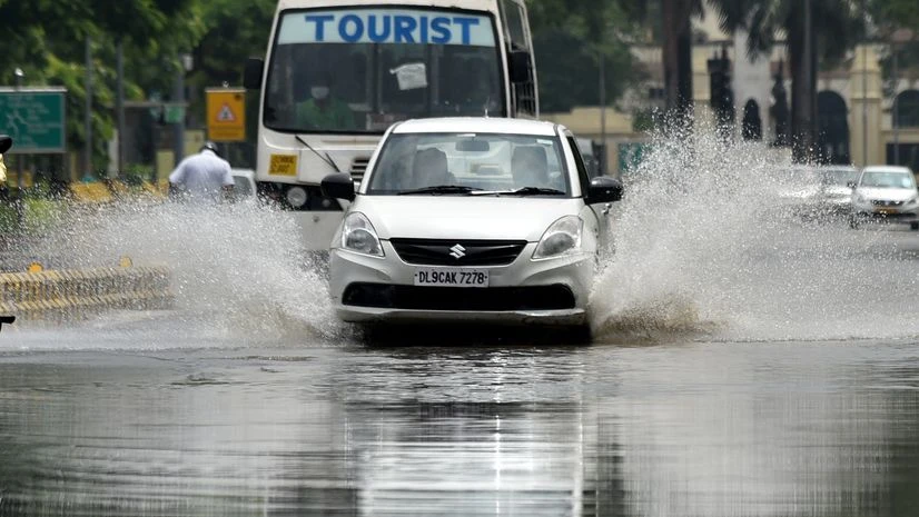 Delhi rain vehicles make their way through a flooded street after heavy rainfall, at South Avenue in New Delhi on Wednesda