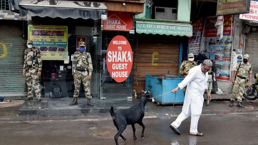 Bakrid Security personnel stand guard as a man heads back after buying a goat on the occasion of Eid al-Adha outside the Jama Masjid during the outbreak of the coronavirus disease (COVID-19), in the old quarters of Delhi on Saturday