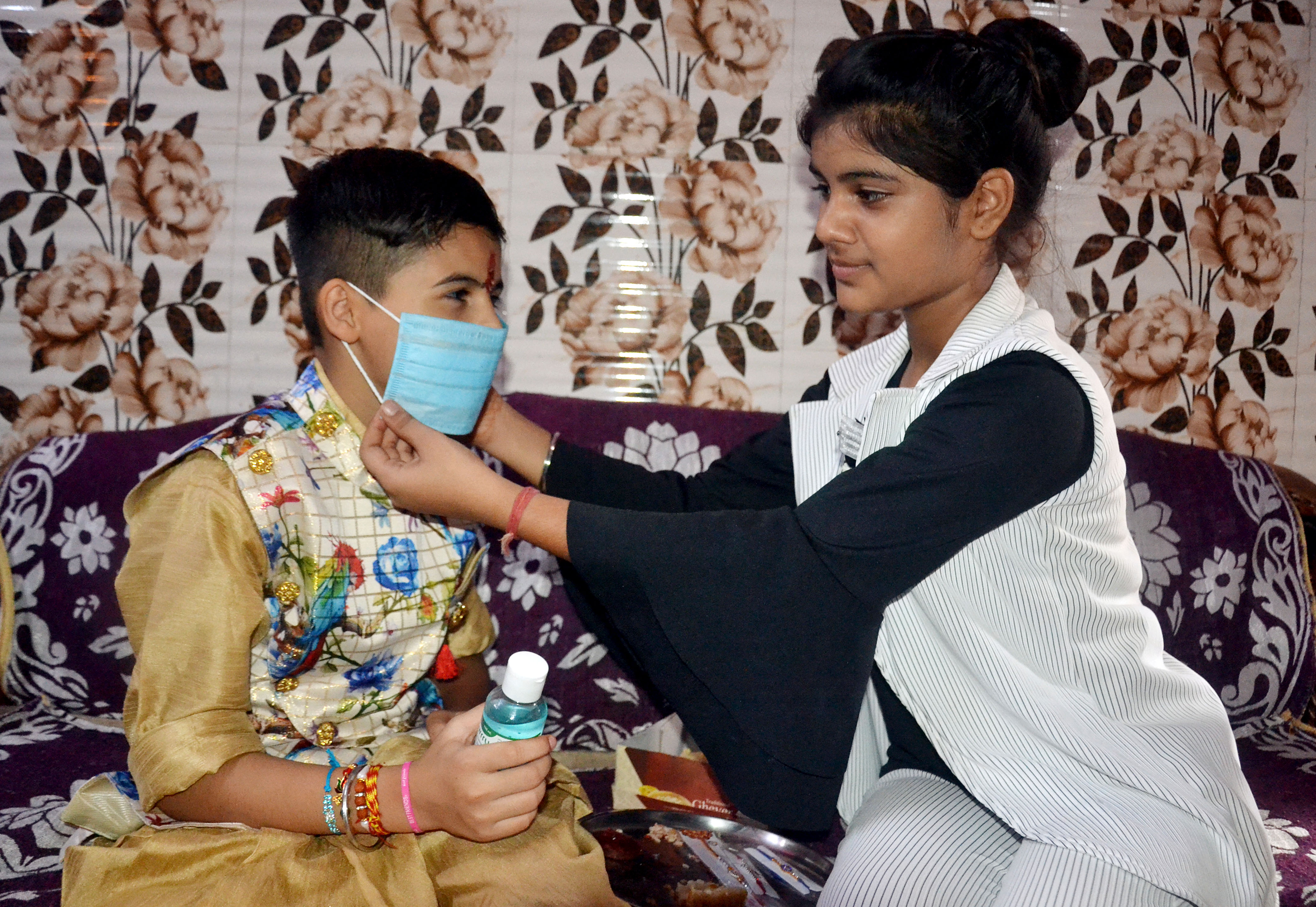 A sister put mask and gave hand sanitiser to her brother after tying rakhi on the occasion of Rakshabandhan, in Agra on Monday A sister put mask and gave hand sanitiser to her brother after tying rakhi on the occasion of Rakshabandhan, in Agra on Monday