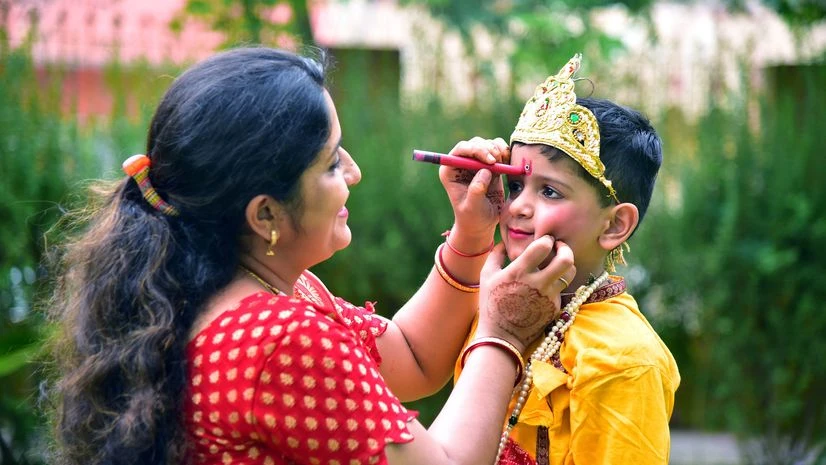Janmashtami A mother dressing her child as Lord Krishna on the eve of Krishna Janmashtami, in Bikane
