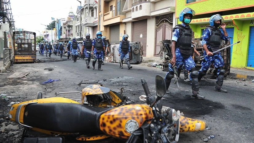 Bengaluru violence Rapid Action Force (RAF) carry out route march at Devara Jeevana Halli where an angry mob attacked and vandalized vehicles and damaged police station and other properties, in Bengaluru.