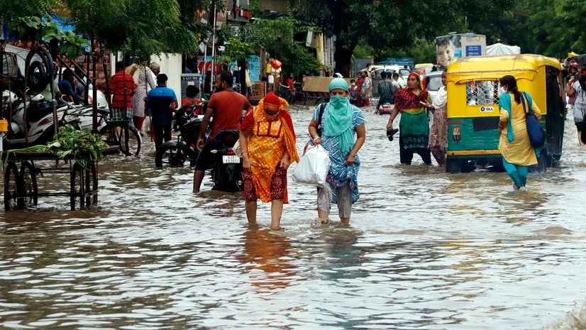 flood People wade through a flooded street after heavy rain in Ahmedabad on Friday.