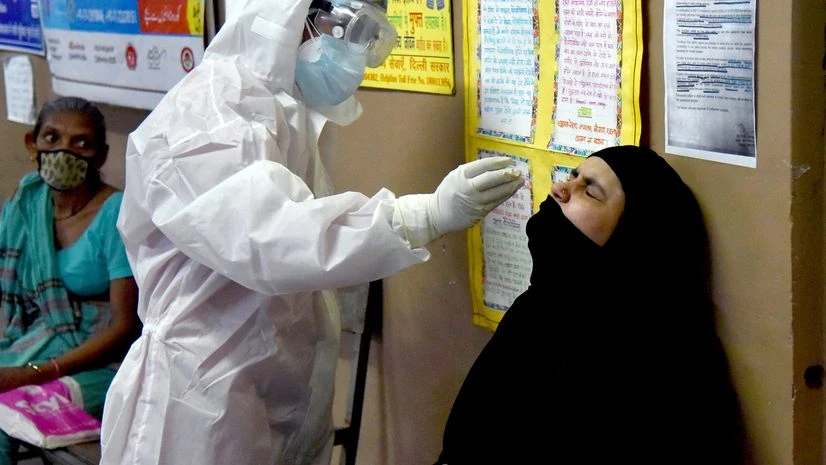 coronavirus A health worker in personal protective equipment (PPE) collects a sample using a swab from a woman at a local health centre to conduct tests for the coronavirus disease (COVID-19), amid the spread of the disease at Ajmeri Gate area, in Delhi.