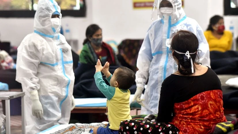 coronavirus, doctors Health workers in PPE kit playing with a child at the Commonwealth Games (CWG) Village sports complex, temporarily converted into a COVID care center, in New Delhi.
