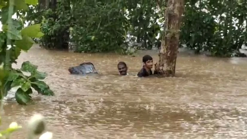 rainfall, Karnataka Two men stuck in a waterlogged area waiting for the NDRF team to get rescued following heavy rainfall in the region, in Udupi.