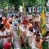 Farmers block railway track as they stage a protest against Farm bills passed by parliament, in Bathinda on Saturday.
