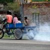 Children ride a cart as smoke came out from it which lead to air pollution, in Noida on Saturday.