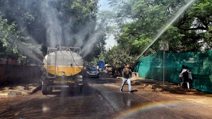 Pollution, New Delhi A worker sprays water on trees to control dust and pollution at the Integrated Exhibition-Cum-Convention Center (IECC) construction sites at Neta Ji Nagar Construction site, in New Delhi on Sunday.