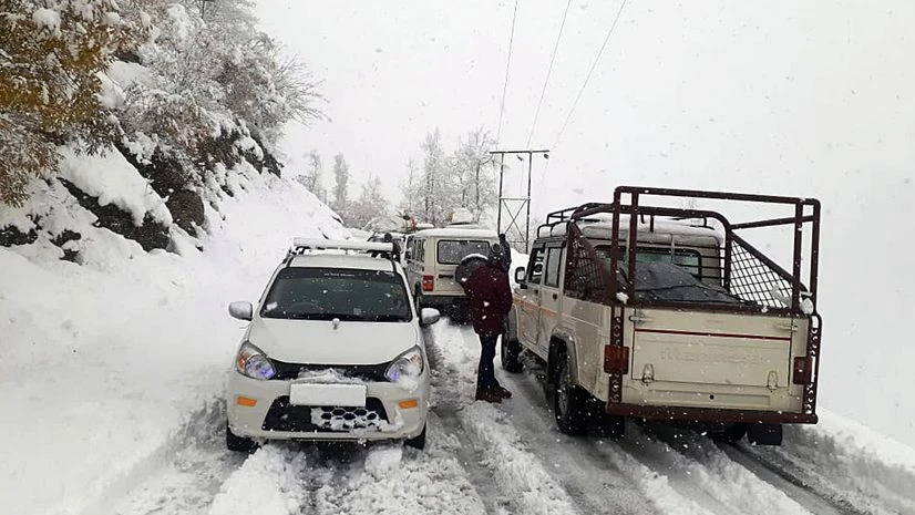 Snowfall, Himachal Vehicles stopped on the road as Sissu area in Lahaul and Spiti district receives snowfall on Monday.