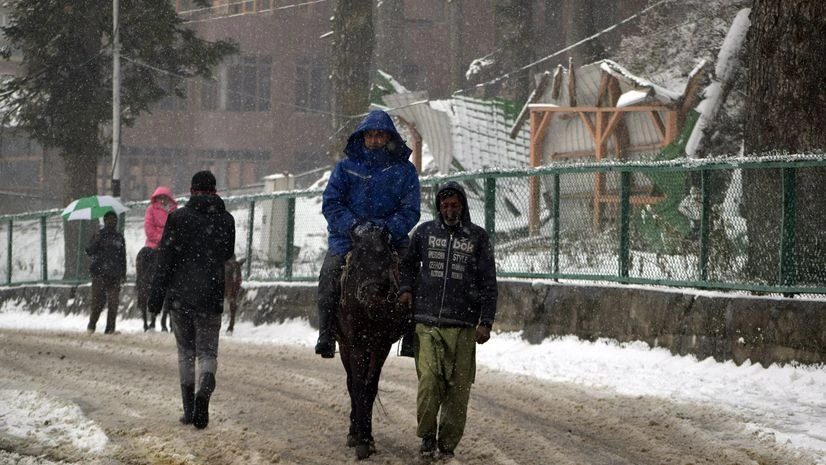 Snowfall, Srinagar Tourists take horse rides to enjoys as Srinagar valley received the first snowfall of the season, in Srinagar on Sunday.