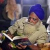 Farmer reads a book during their protest against new farms law, at Singhu Border in New Delhi on Saturday.