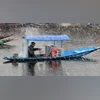 A boatman rides a shikara during fresh snowfall, in Srinagar