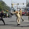 A Protester hits police personnel with a rod after breaching the route during the tractor rally at ITO in New Delhi
