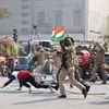 Police personnel lathi-charge on protesting farmers at ITO during the tractor rally on 72nd Republic Day in Delhi