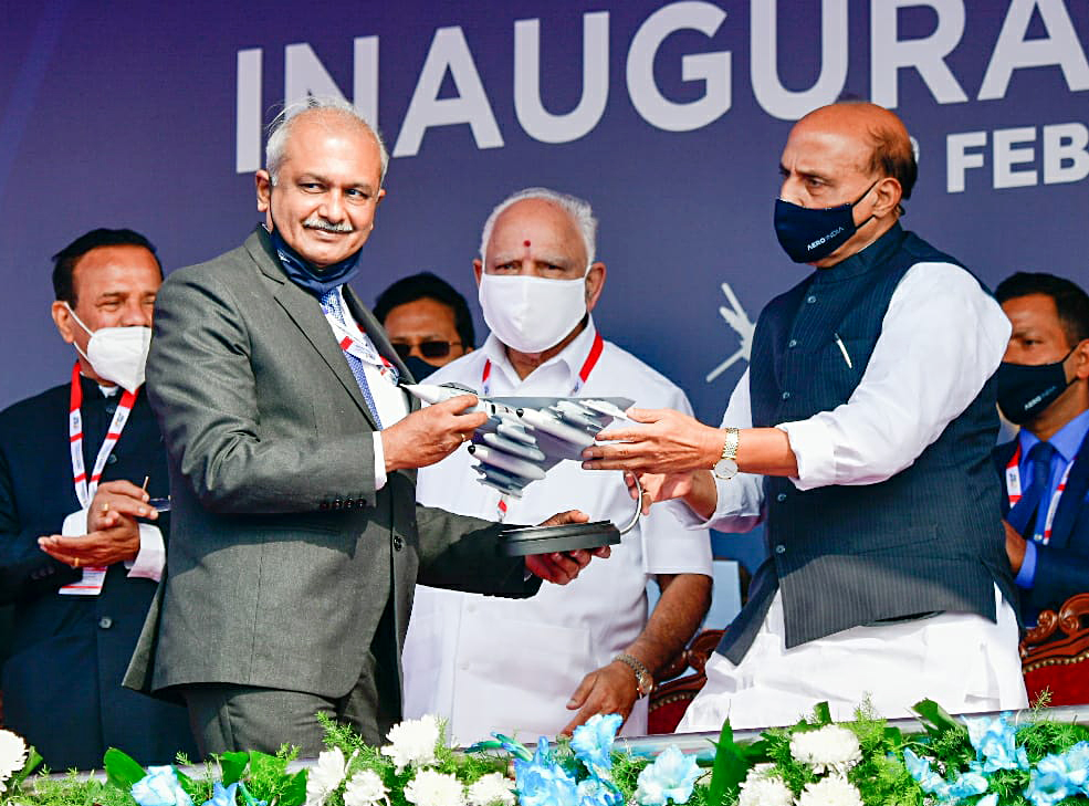 Defence Minister Rajnath Singh hands over a model of Tejas aircraft to HAL Chairman R Madhavan during the inauguration of the 13th edition of Aero India Defence Minister Rajnath Singh hands over a model of Tejas aircraft to HAL Chairman R Madhavan during the inauguration of the 13th edition of Aero India